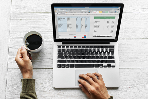A person working on graphic design software with various design elements on the screen